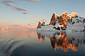 Reflections of cliffs and mountains in the Lemaire Channel at sunset,Antarctica