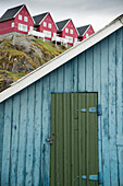 Padlocked door in a shack overlooked by housing on a ridge,Sisimiut,Greenland