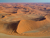 Blick aus der Luft auf die kilometerlangen, vom Wind verwehten Sanddünen im Namib-Naukluft Park, Sossusvlei, Namibia