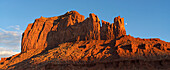 Felsformationen im Monument Valley, Arizona.  Die roten Felsen leuchten bei Sonnenuntergang, wenn das Licht auf sie trifft, Arizona, Vereinigte Staaten von Amerika