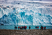 Ökotouristen in der Nähe eines blauen Eisgletschers über dem Krossfjord, Spitzbergen, Svalbard Archipelago, Norwegen