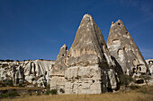 In Felsformationen gehauene Höhlenhäuser vor einem strahlend blauen Himmel in der Nähe der Stadt Goreme im Pigeon Valley, Region Kappadokien, Provinz Nevsehir, Türkei
