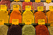 Colorful spices for sale,heaped in plastic bins with metal scoops on display in a shop in the Spice Bazaar in the Fatih District,Istanbul,Turkey