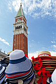 Souvenirhüte zum Verkauf auf dem Markusplatz mit dem Campanile im Hintergrund,Venedig,Italien