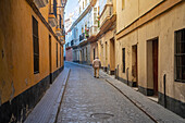 Ein älterer Mann geht die schmale Straße zwischen Wohnhäusern entlang, Cadiz, Andalusien, Spanien