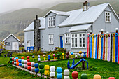Ein bunter Spielplatz neben einem Haus in Seydisfjordur, einer Stadt und Gemeinde in der östlichen Region Islands an der innersten Spitze des gleichnamigen Fjords. Eine Straße über den Fjardarheidi-Pass verbindet Seydisfjordur mit dem Rest von Island, Seydisfjordur, Ostregion, Island