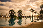 Swimming pool and reflected trees in an off-season Spanish resort,Caparott,Menorca,Spain