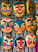 Bunt bemalte Gesichter auf dem Boden von geflochtenen Körben als Masken, die als asiatisches Volkskunsthandwerk zum Verkauf angeboten werden, Hanoi, Vietnam