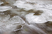 Fließendes Wasser um Eis auf der Oberfläche eines Baches, Columbia Basin, Oregon, Vereinigte Staaten von Amerika