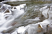 Wasser fließt über schnee- und eisbedeckte Felsen, Columbia River Gorge, Oregon, Vereinigte Staaten von Amerika