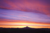 Dramatische leuchtende Wolken über einem silhouettierten Mount Hood bei Sonnenaufgang, Oregon, Vereinigte Staaten von Amerika