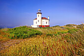 Coquille River Light on the Oregon coast with grasses in a field in the foreground,Bandon,Oregon,United States of America