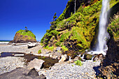 Wasserfall und eine Felsformation am Strand entlang der Küste von Oregon, Oregon, Vereinigte Staaten von Amerika