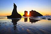 Silhouettierte Felsformationen am Bandon Beach bei Sonnenuntergang und Ebbe,Oregon Küste,Oregon,Vereinigte Staaten von Amerika