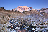 Bach, der vom schneebedeckten Mount Rainier bei Sonnenaufgang im Mount Rainier National Park fließt, Washington, USA