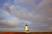 Yaquina Head Light unter bewölktem Himmel entlang der Küste von Oregon mit dem Horizont des Pazifischen Ozeans im Hintergrund, Oregon, Vereinigte Staaten von Amerika