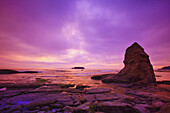 Warmes Sonnenuntergangslicht über der Küste von Oregon mit ruhigem Wasser und Felsformationen und dem Horizont in der Ferne,Oregon,Vereinigte Staaten von Amerika
