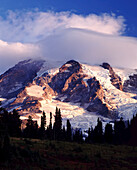 Eine Wolkenformation, die sich über dem Gipfel des Mount Rainier im Mount Raininer National Park, Washington, Vereinigte Staaten von Amerika, abzeichnet und diesen verdunkelt