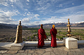 Buddhist monks blowing horns on the roof of Thikse Monastery above the Indus Valley,in the Himalayan Mountains of Ladakh,Jammu and Kashmir,Thiksey,Ladakh,India