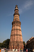 Qutb Minar,a minaret standing tall against a blue sky,New Delhi,Delhi,India