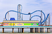 Touristen fahren auf einer Achterbahn am Galvaston Island Historic Pleasure Pier, Galvaston, Texas, Vereinigte Staaten von Amerika