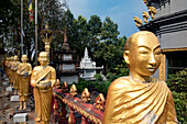 Reihe von goldbemalten Mönchsfiguren im buddhistischen Kloster in Sihanoukville, Kambodscha, Krong Preah Sihanouk, Sihanoukville, Kambodscha