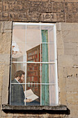 Wandgemälde an der Fassade eines Hauses, das einen Mann zeigt, der in seiner Hausbibliothek in Bath, England, Bath, Somerset, England, ein Buch betrachtet