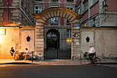 In der Abenddämmerung isst ein Paar in einem Restaurant im Freien, während ein Mann mit dem Fahrrad fährt,Paris,Frankreich