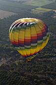A hot air balloon flies over agriculture and vineyards in California,east of Napa Valley.,Winters,California