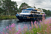 A tour boat cruises along the Caledonian Canal near Fort Augustus,Scotland,Fort Augustus,Scotland