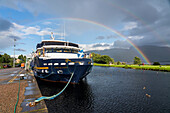 A rainbow spans the sky above a tour boat docked along the Caledonian Canal in Corpach,Scotland,Corpach,Scotland