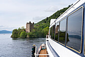 Tour boat cruises past Urquhart Castle ruins in Loch Ness,Scotland,Fort Augustus,Scotland