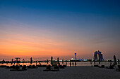 Ein Beach Club unter der untergehenden Sonne im Persischen Golf mit Blick auf Marina Island, Abu Dhabi, Vereinigte Arabische Emitariten