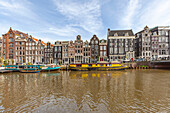 Barges moored on Singel canal in front of traditional houses in Amsterdam,Amsterdam,North Holland,Netherlands
