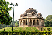 Traditionelle indische Architektur eines Hindu-Tempels im Lohdi Park, mit einem Mann, der eine Frau fotografiert, Dehli, Indien