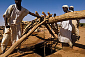 Sudanesische Bauern holen Wasser aus einem tiefen Brunnen in der Nähe der archäologischen Stätte in Naqa,Naqa,Sudan,Afrika.