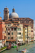 Grand Canal with a cathedral dome and tower in the skyline,Venice,Veneto,Italy