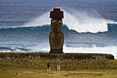 Tourists stand in front of a Moai at Ahu Tahai Ceremonial complex,Rapa Nui National Park on Easter Island,Easter Island