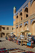 Waren zum Verkauf und Islam Khoja Madrasah in Itchan Kala, UNESCO-Weltkulturerbe, in Chiwa, Usbekistan, Chiwa, Usbekistan