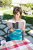 Lesende Frau im Hinterhof