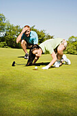 Golfer versucht, den Golfball ins Loch zu pusten