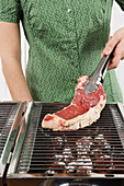 Frau grillt ein Steak