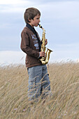 Boy Playing Saxophone in Field