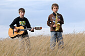 Musik spielende Jungen auf einem Feld