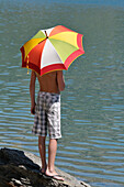 Back View of Boy using Umbrella in Sun,Alps,France