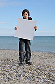 Junge hält leere Leinwand am Strand, Sete, Frankreich