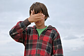 Porträt eines Jungen mit Hand über den Augen, Ile de Re, Frankreich