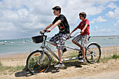 Brüder fahren Tandemfahrrad am Strand,Ile de Re,Frankreich