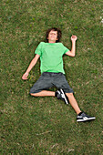 Junge auf Gras liegend, Ile de Re, Poitou-Charentes, Frankreich