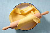 Overhead View of Pie Crust in Pie Plate and Rolling Pin on Blue Background,Studio Shot